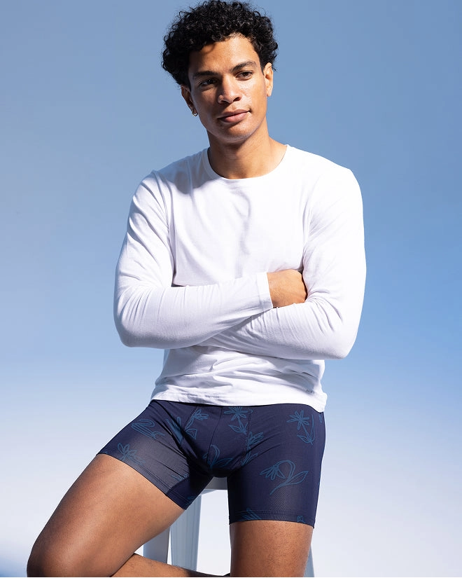 Smiling model in a white long-sleeve tee and navy boxer briefs
