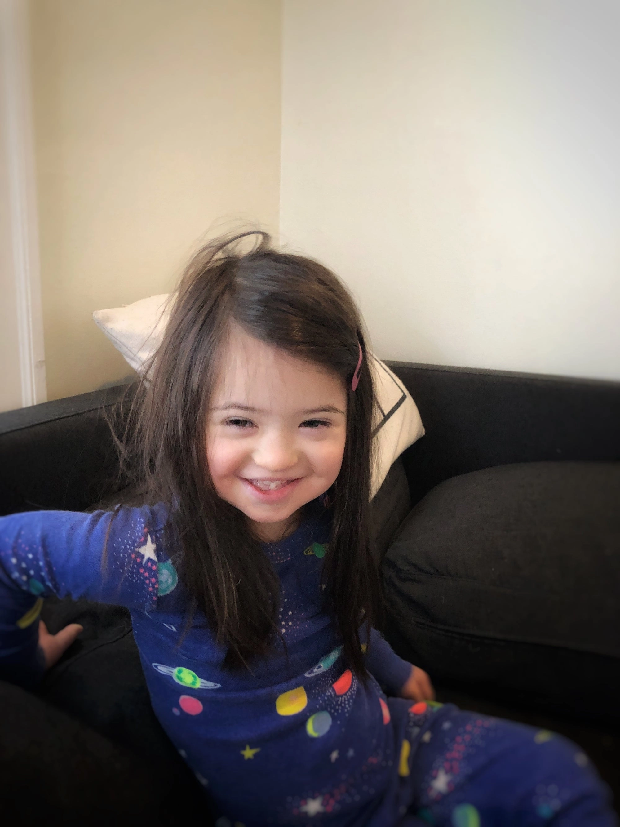 Ayala smiling on a couch in star-print pajamas