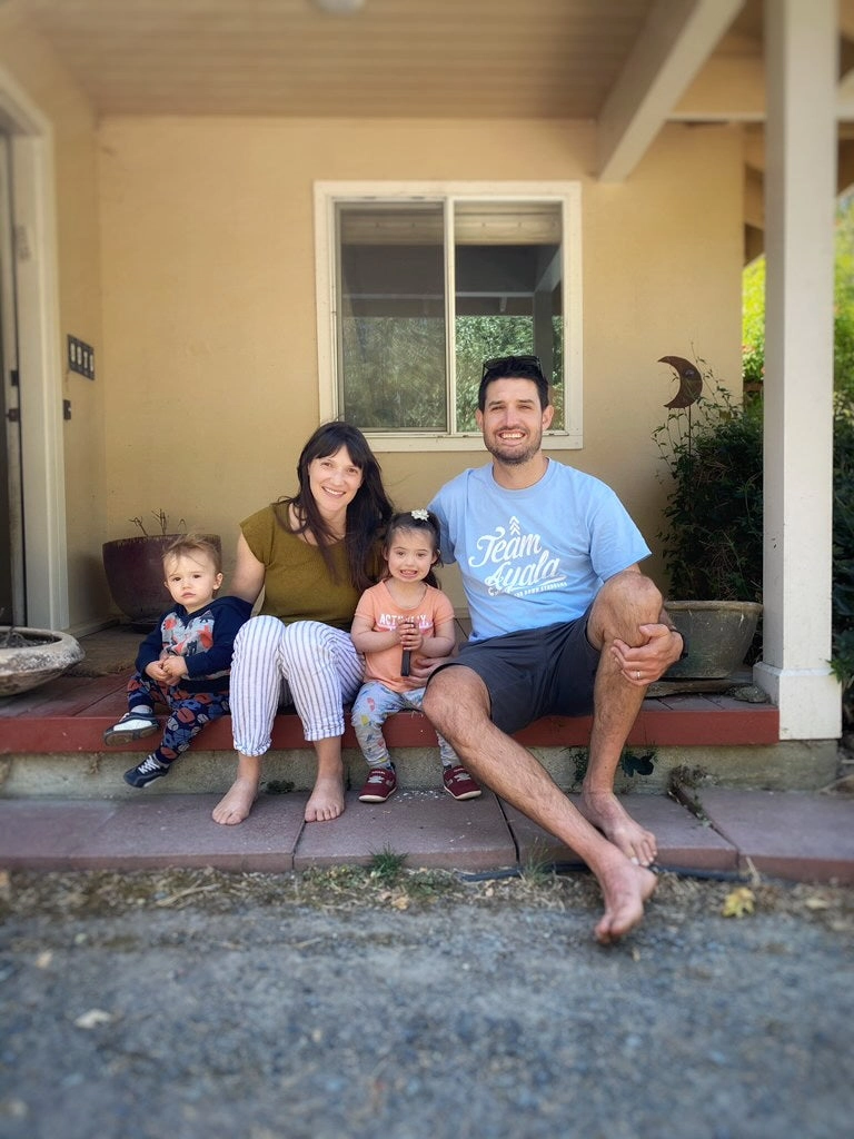 A family of four sitting on a porch step